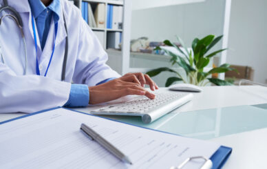 Hands of female doctor typing on keyboard